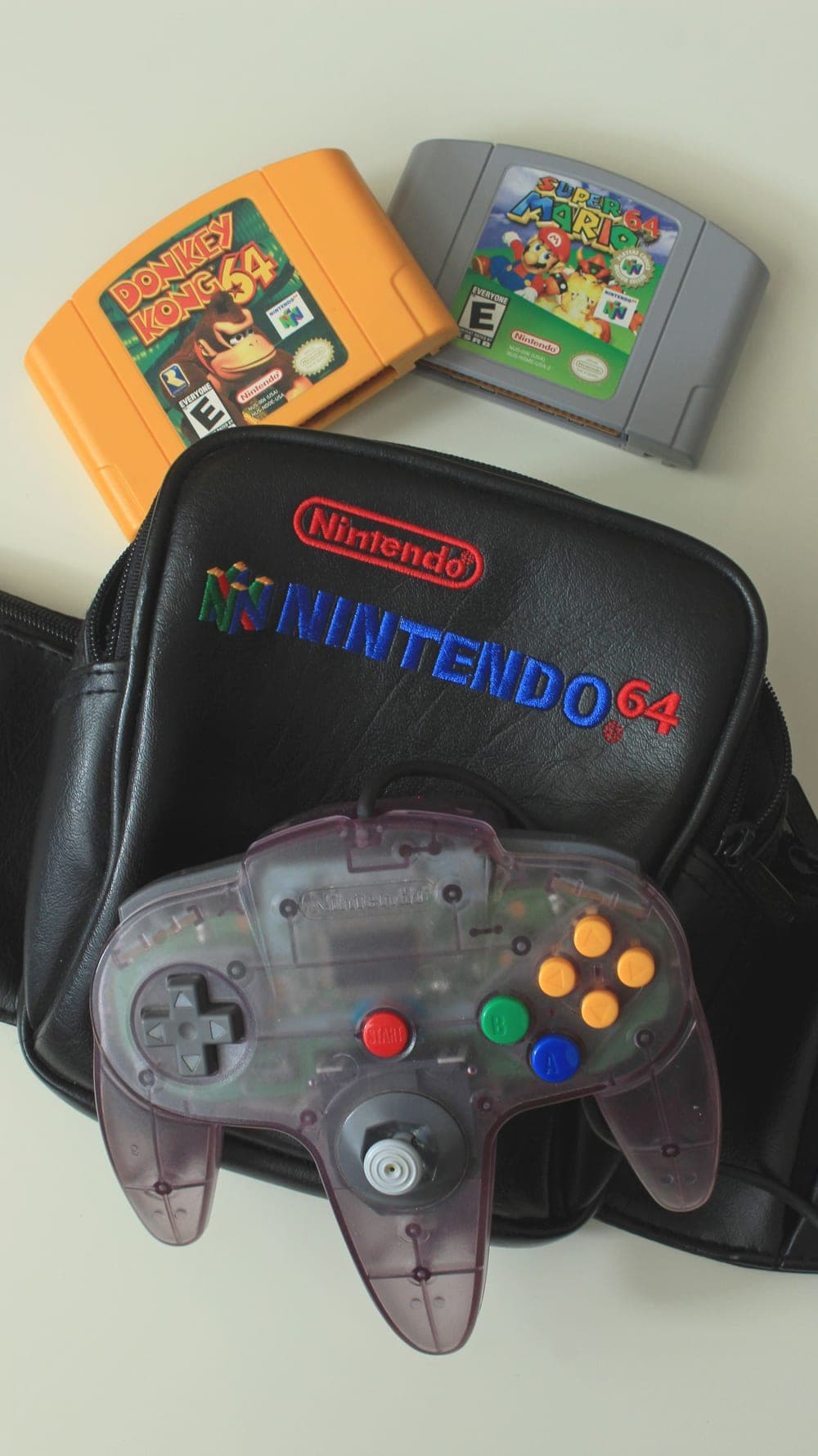 A stack of budget video games and a controller — cheap games that are actually good